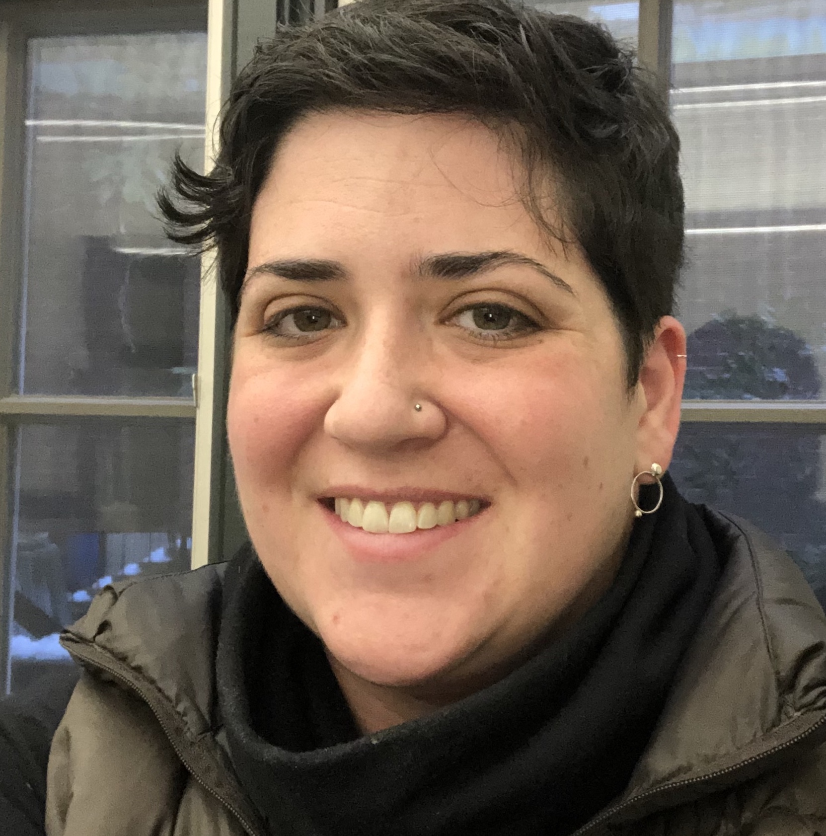 photo of a smiling white woman with dark hair and a short haircut