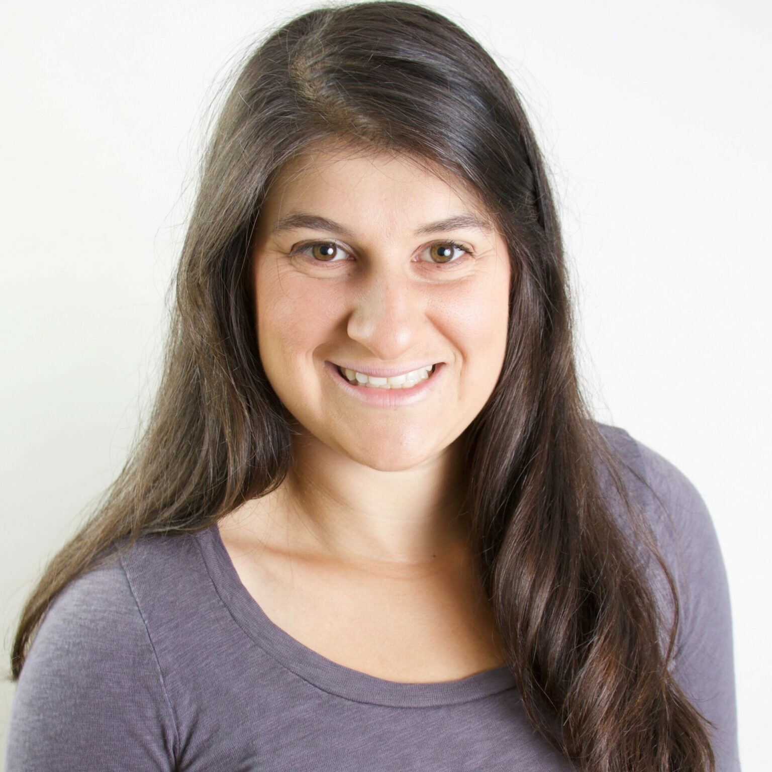 photo of a smiling white woman with long, dark, straight hair