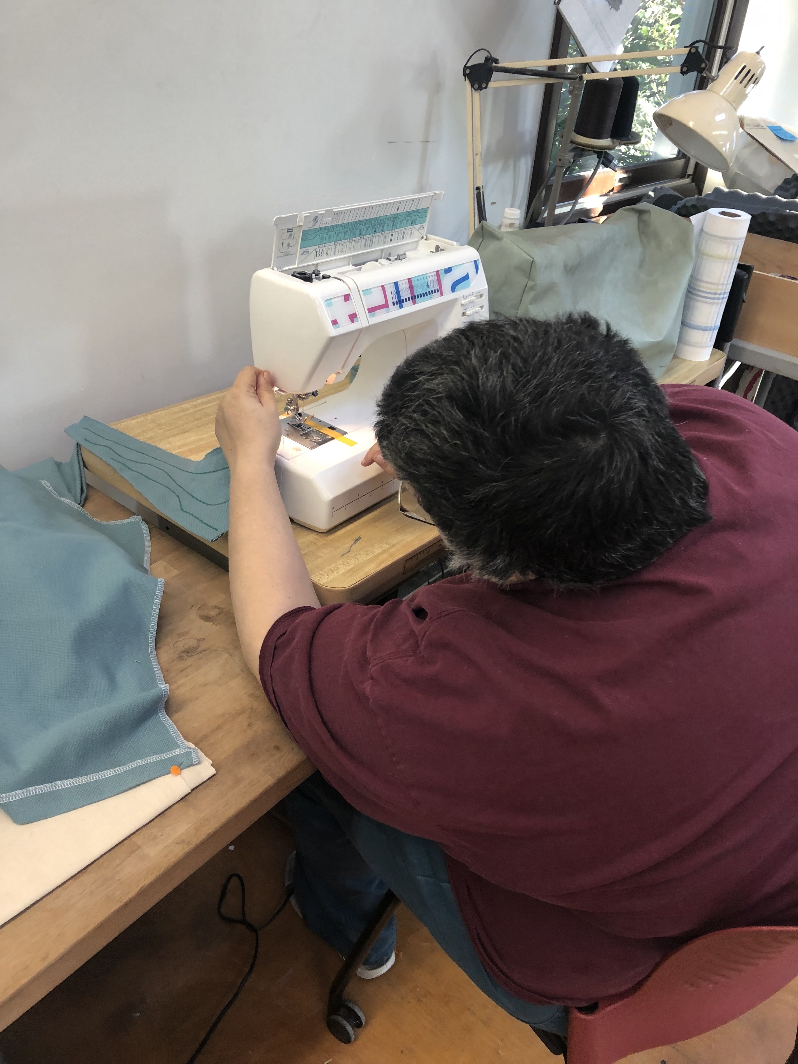 back view of a person working at a sewing machine